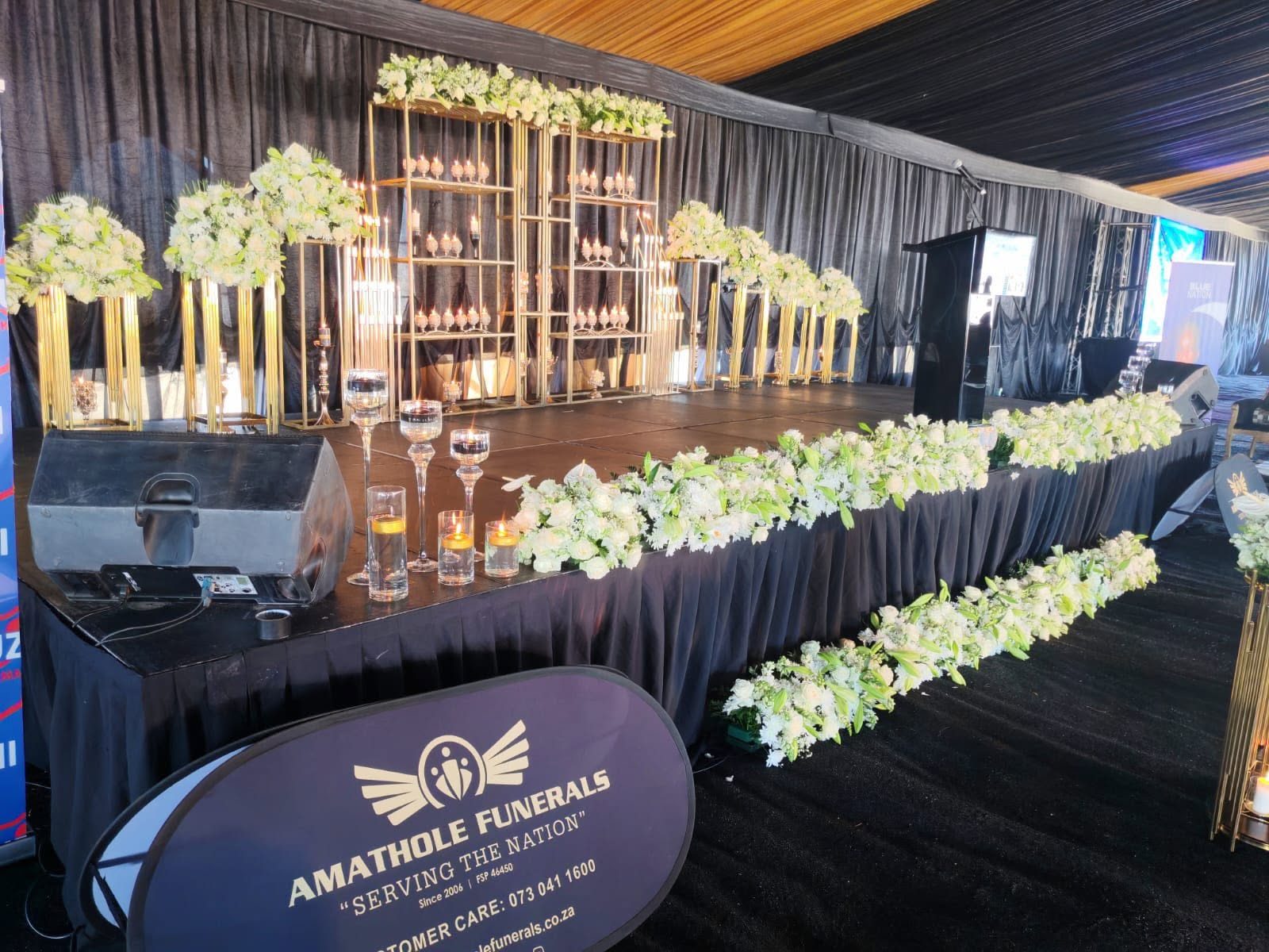 Floral tribute and candlelit staging at an Amathole memorial service